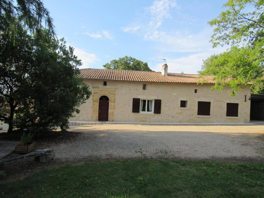 una antigua casa de piedra con una gran entrada en La Maison des Graves, en Pujols Gironde