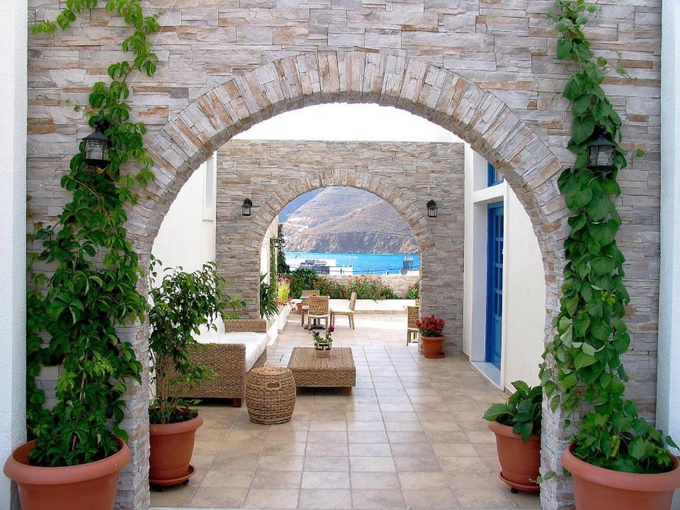 an archway with potted plants in a patio at Karkisia Hotel in Aegiali
