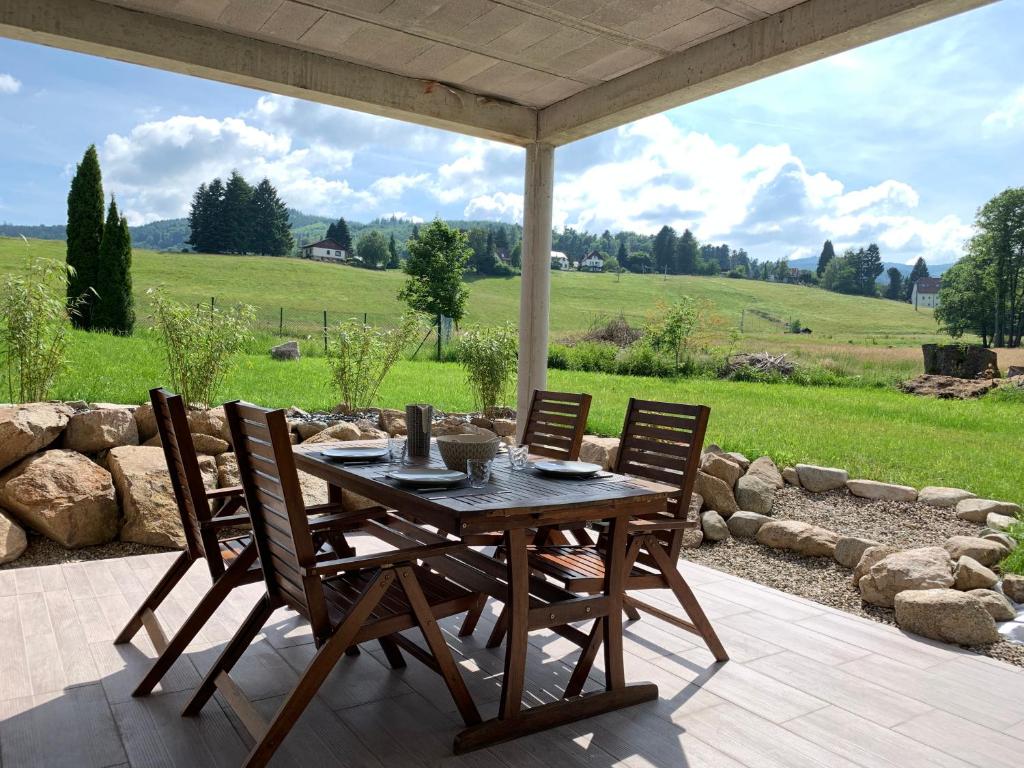 una mesa de madera y sillas en un patio en Gîte au cours d’eau en Le Hohwald