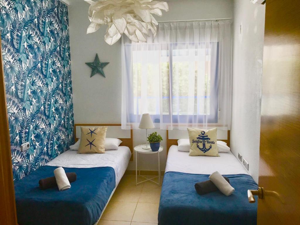 1 dormitorio con 2 camas en azul y blanco en Alicante Hills Apartment Blue, en Alicante