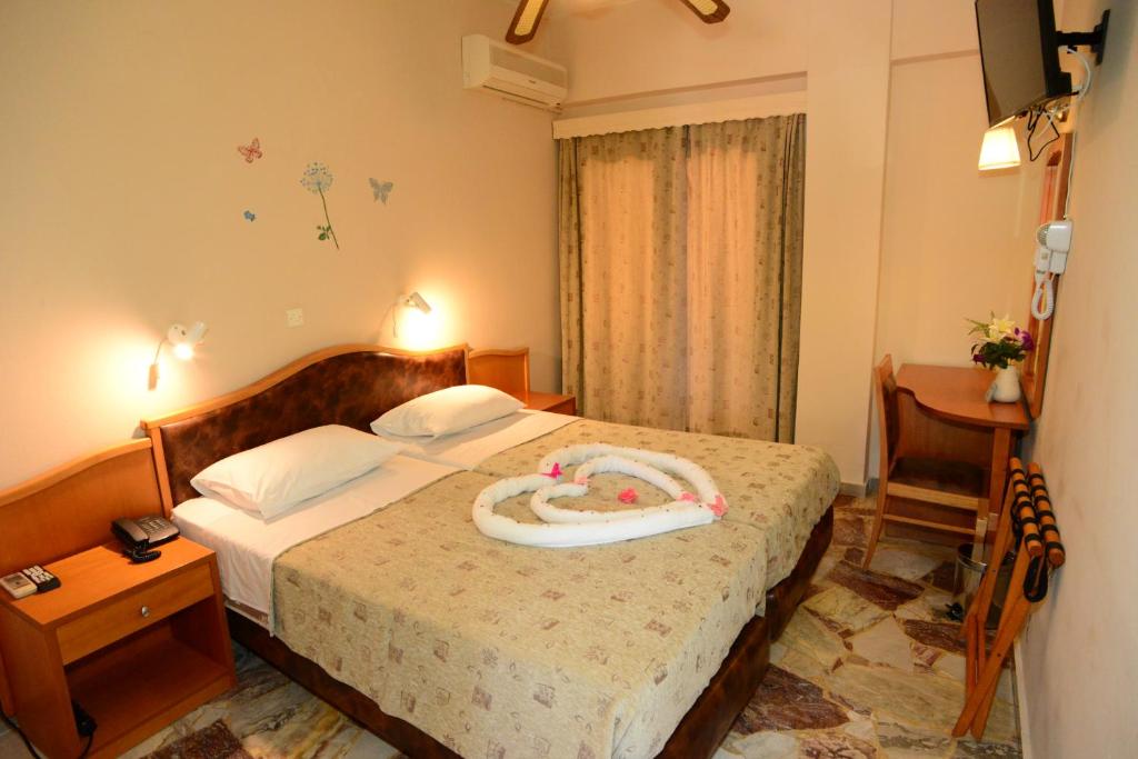 a hotel room with a bed with a pacifier on it at Sappho Hotel in Skala Eresou