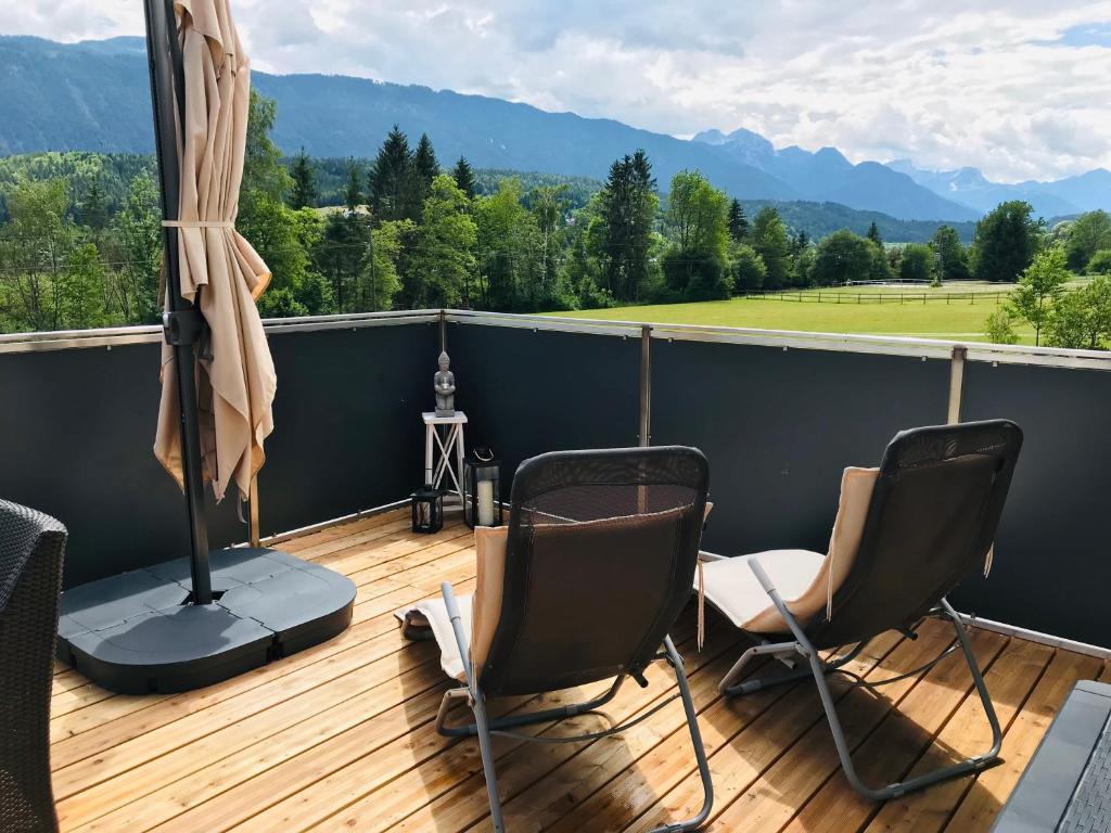 a balcony with chairs and a view of the mountains at Berglust Und Seenliebe in Lake Pressegg