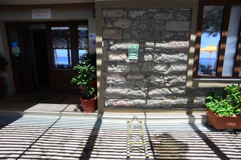 a front door of a house with potted plants at Sappho Hotel in Skala Eresou