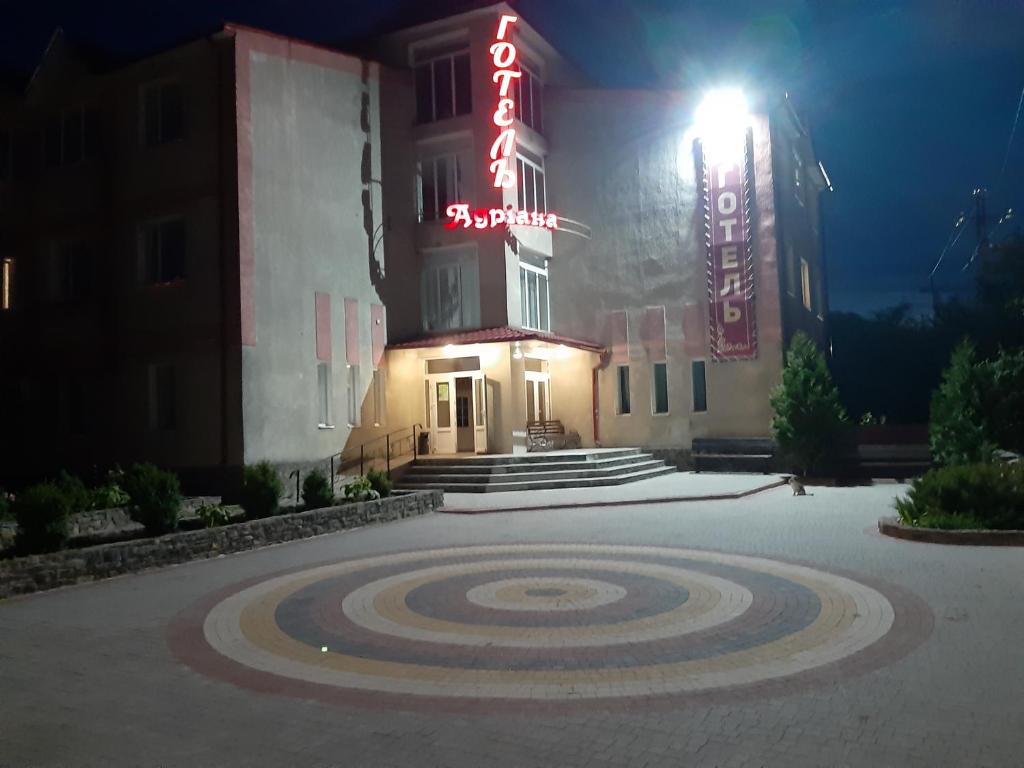 un hotel de noche con un objetivo delante de él en Готель Адріана, en Dunaivtsi