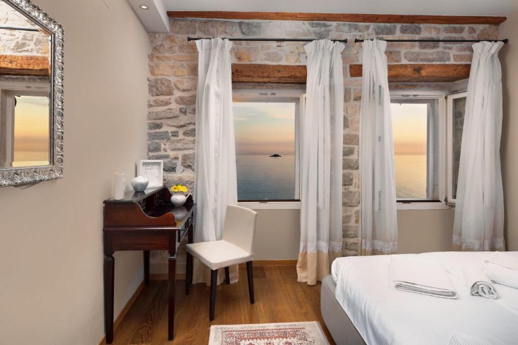 a bedroom with a bed and a desk and a window at Angelo d'Oro Apartment Monte in Rovinj