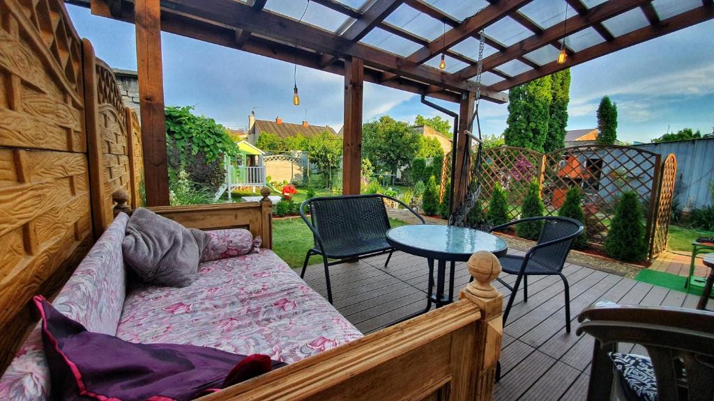 een veranda met een bed en een tafel op een patio bij Dom Adula in Janów Lubelski