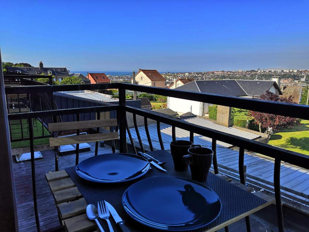 una mesa con un gato en la parte superior de un balcón en Escale Dieppe Gambetta - Appart et Studios 2-6 personnes Vue Ville et Mer, en Dieppe