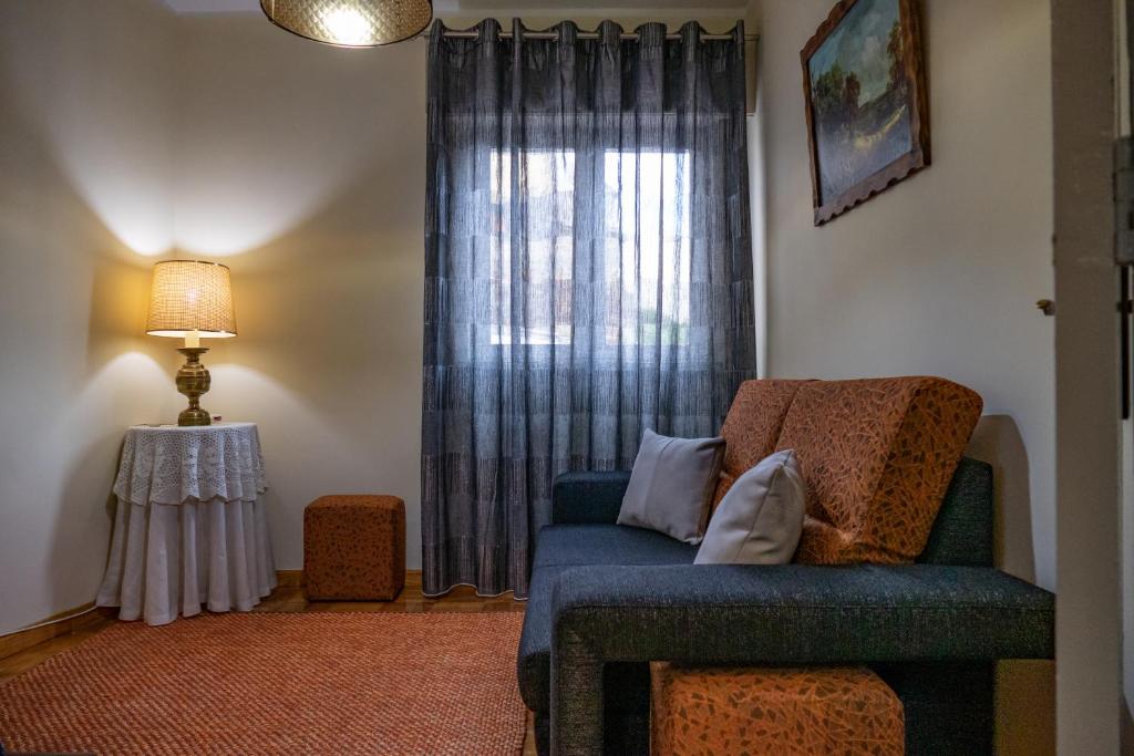 sala de estar con sofá azul y ventana en TUACASA, en Mirandela