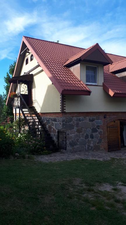 a house with a red roof and a staircase at Czerwonki agroturystyka u Beaty in Czerwonki