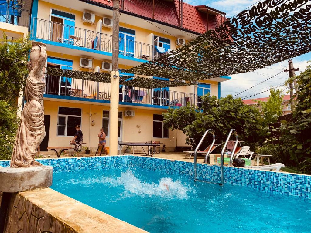 una piscina frente a un edificio en Uyutnaya Laguna Guest House, en Loo