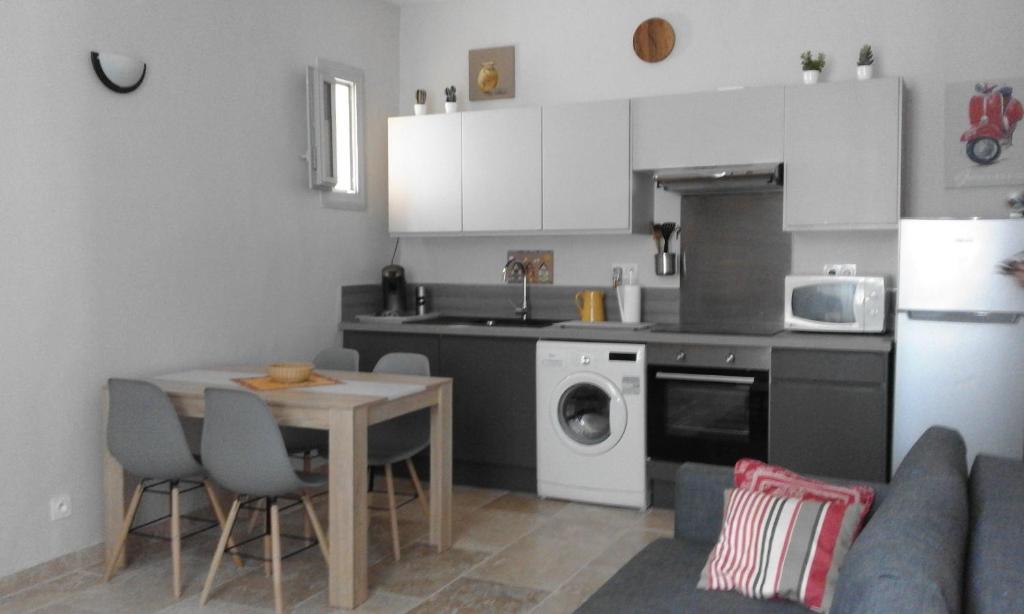 une cuisine avec une table et une cuisine avec un lave-linge dans l'établissement ST REMY DE PROVENCE PROCHE CENTRE VILLE - Parking privé, à Saint-Rémy-de-Provence