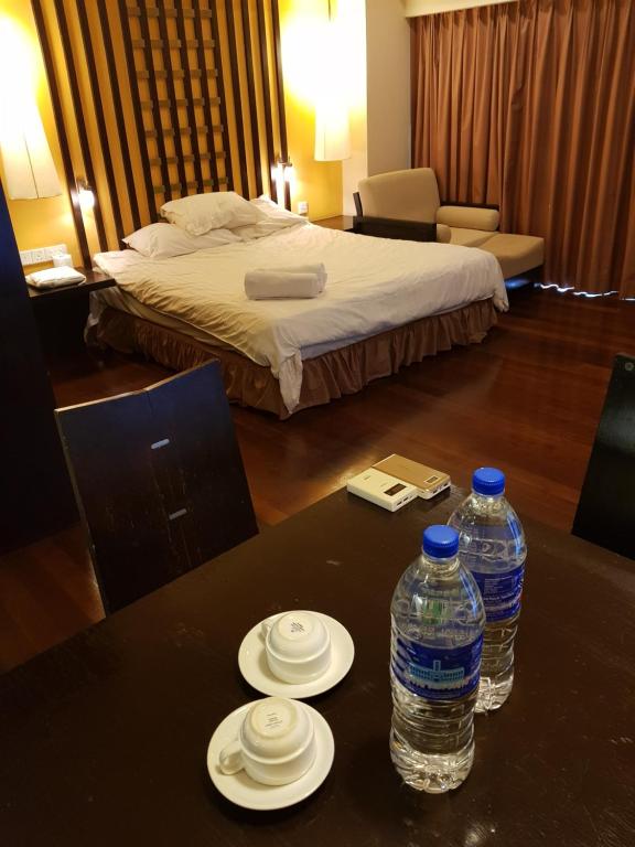 a hotel room with two bottles of water on a table at Sunway Luxury Suites in Kampong Penaga