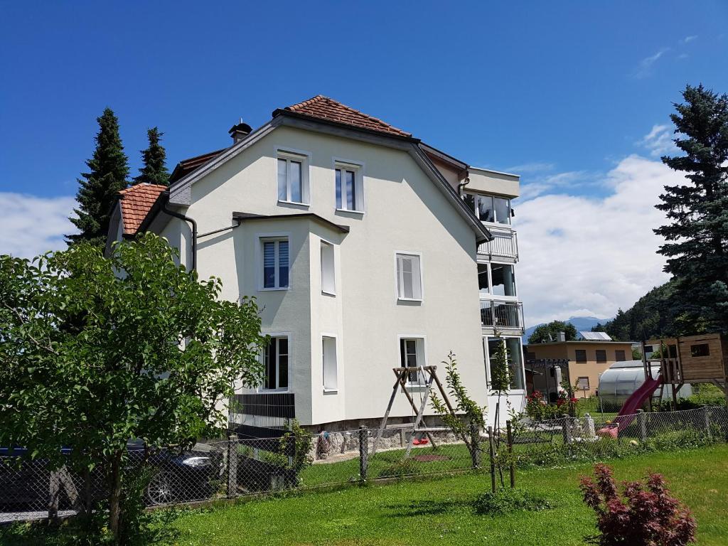 une grande maison blanche dans une cour dans l'établissement Green Hill Apartments - Feldkirch, à Feldkirch