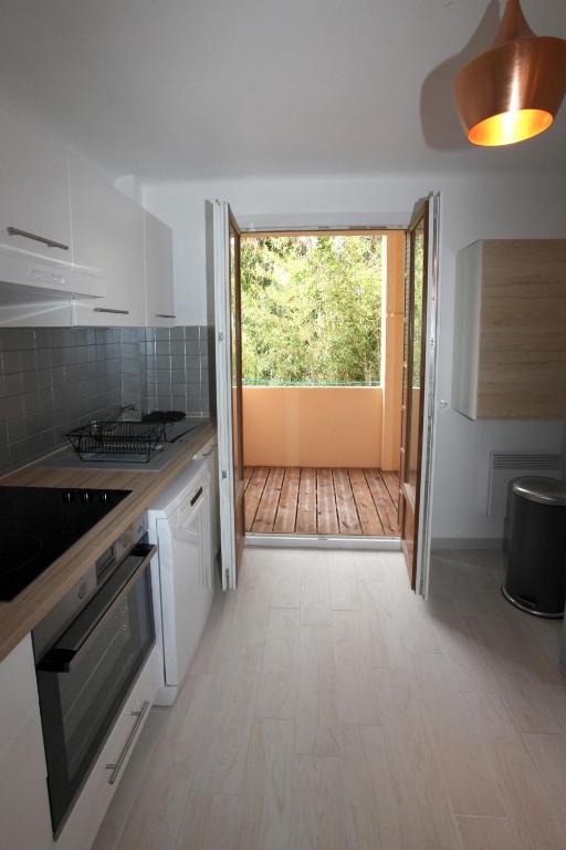 a kitchen with a door leading to a deck at Résidence La Source in Toulon