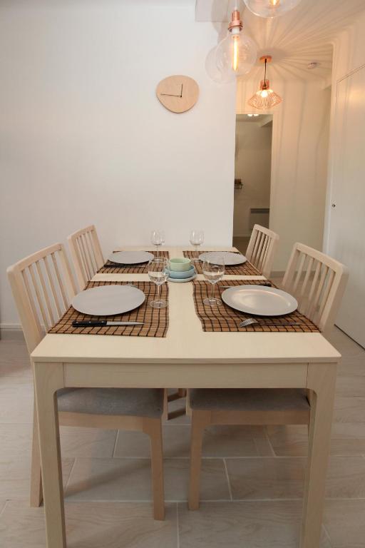 a dining room table with chairs and plates on it at Résidence La Source in Toulon