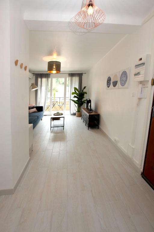 a living room with white walls and a hard wood floor at Résidence La Source in Toulon