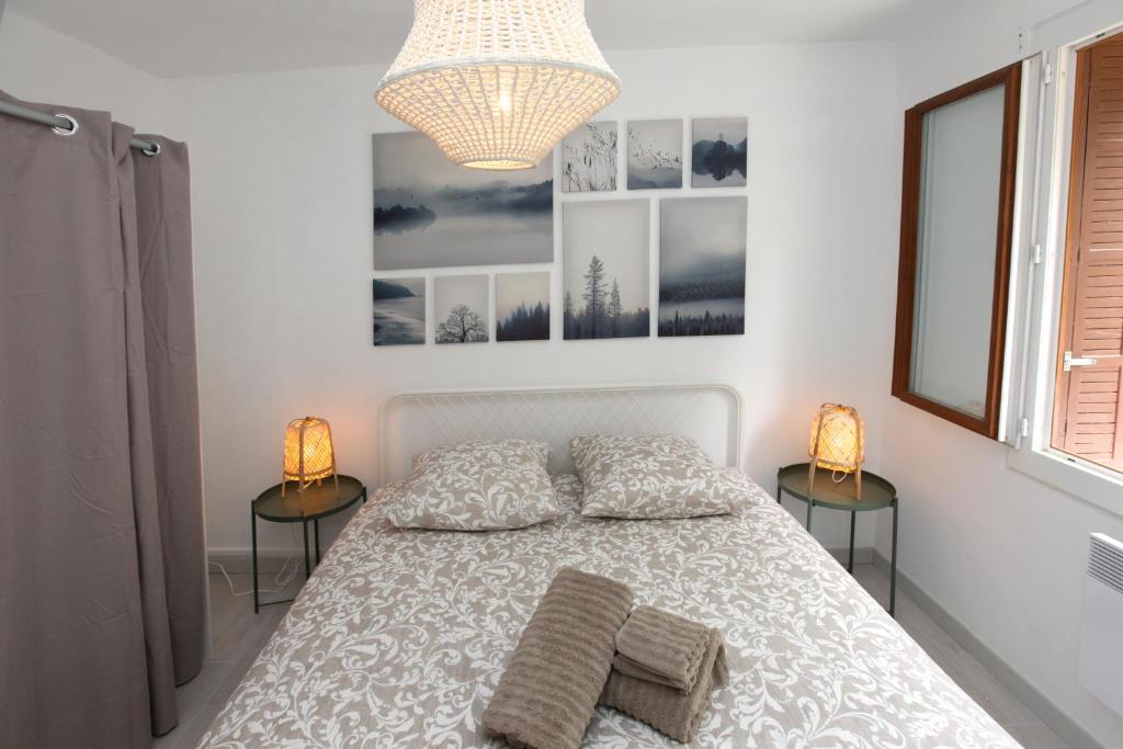 a bedroom with a bed with two lamps and a window at Résidence La Source in Toulon
