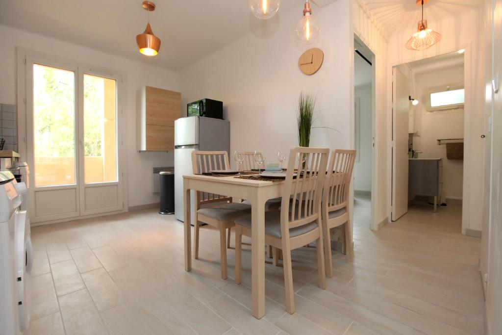 a kitchen and dining room with a table and chairs at Résidence La Source in Toulon