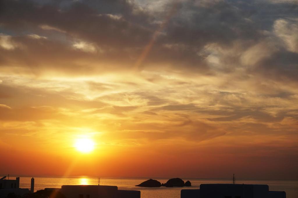 un tramonto sull'oceano con il sole nel cielo di Sunset Villa II a Nea Cryssi Akti