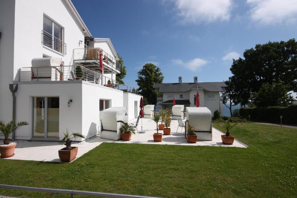 Una casa blanca con plantas en macetas en un patio. en Appartement Nr 7 im Sonnenbad, en Sassnitz
