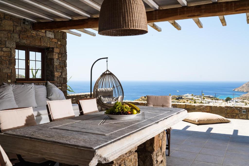 a dining room table with a view of the ocean at Elia Horizon Mykonos in Elia Beach