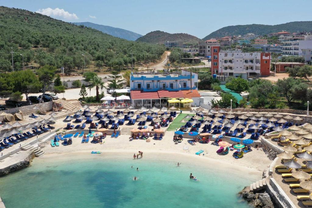 - une plage avec des parasols et des personnes dans l'eau dans l'établissement Hotel Artur, à Ksamil