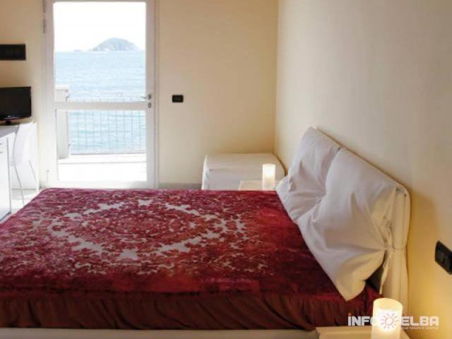 a bedroom with a large bed with a window at B&B LE FORNACELLE in Rio Marina