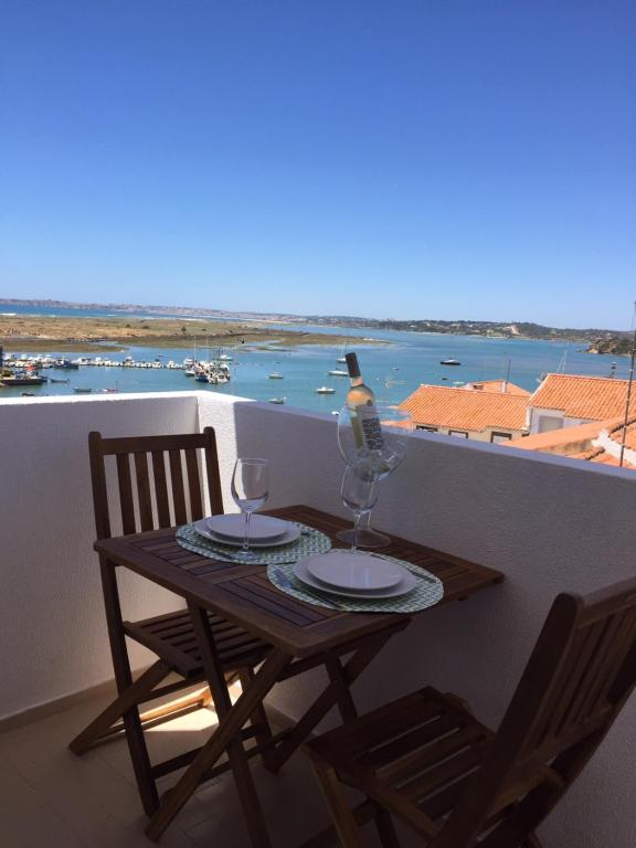 - une table avec 2 verres et une bouteille de vin sur le balcon dans l'établissement Casa Villa D’Alvor, à Alvor