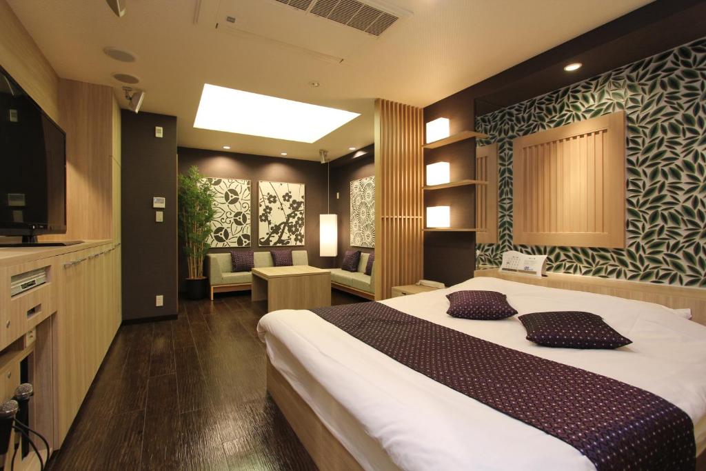 1 dormitorio con 1 cama grande y cocina en HOTEL K-WAVE R (Adult Only), en Koshigaya