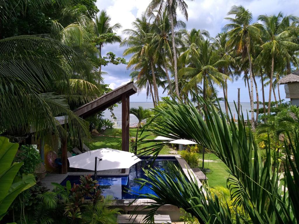 un complejo con piscina y palmeras en Daluyong Beach Resort en General Luna