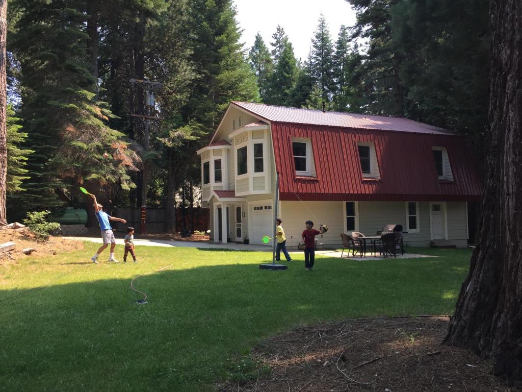um grupo de pessoas jogando frisbee em frente a uma casa em Carriage House at Yosemite em Fish Camp
