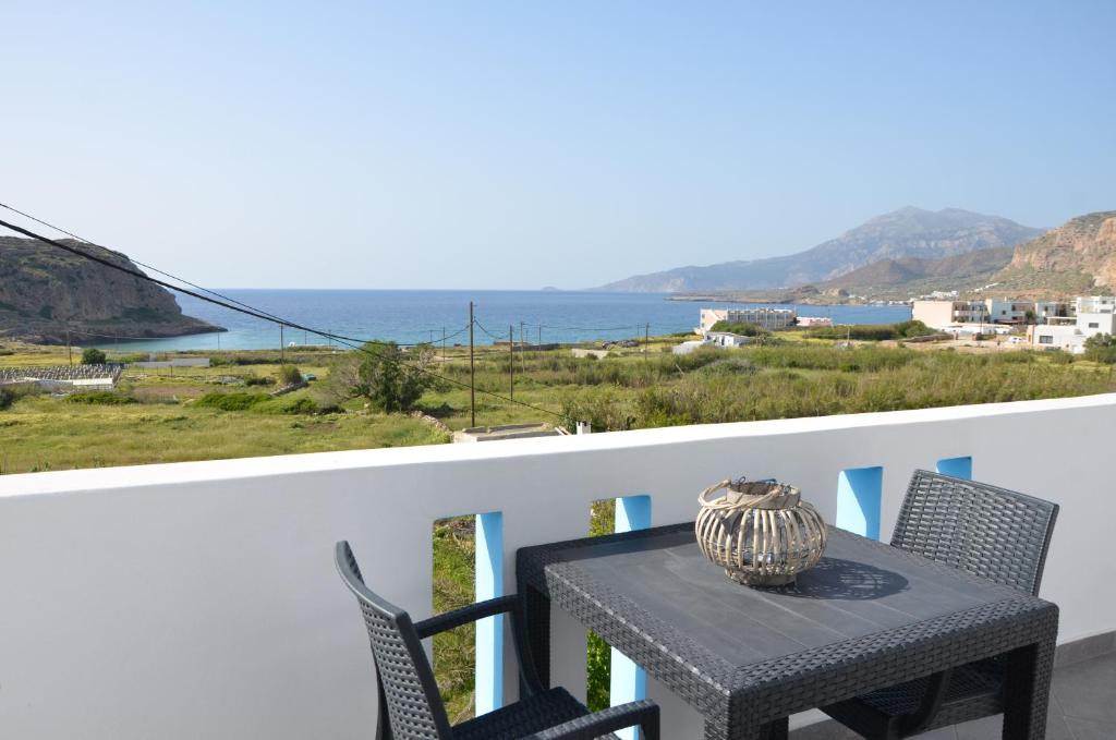 a table and chairs on a balcony with a view of the ocean at Palaiokastro view in Karpathos Town
