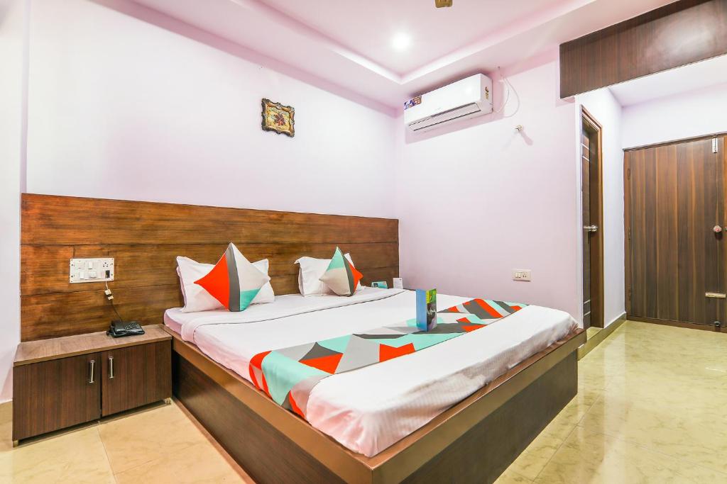 a bedroom with a large bed with a wooden headboard at Yashaswi Comforts in Mysore