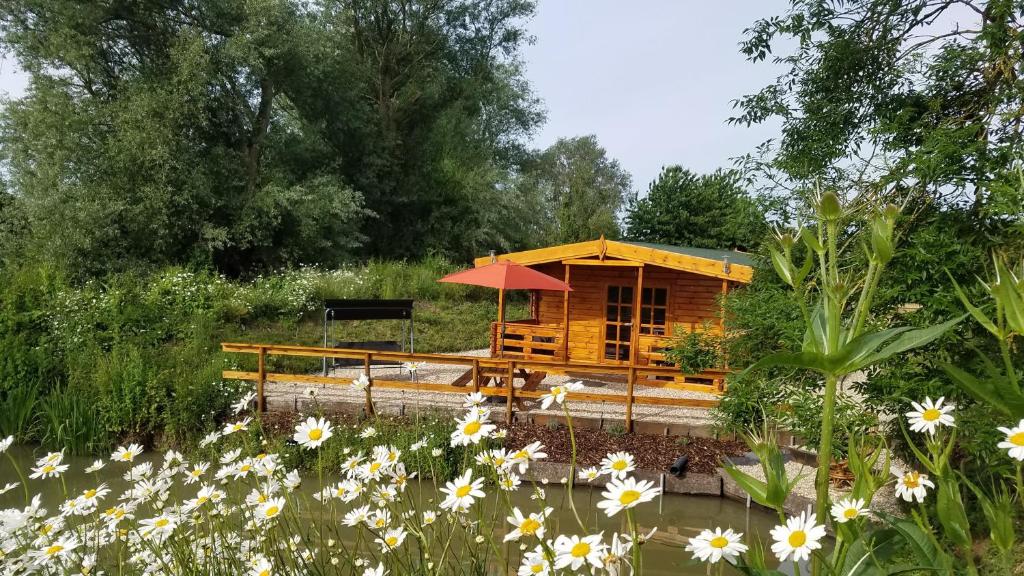 a small wooden cabin in a field of flowers at East Pool Cabin in Lincoln