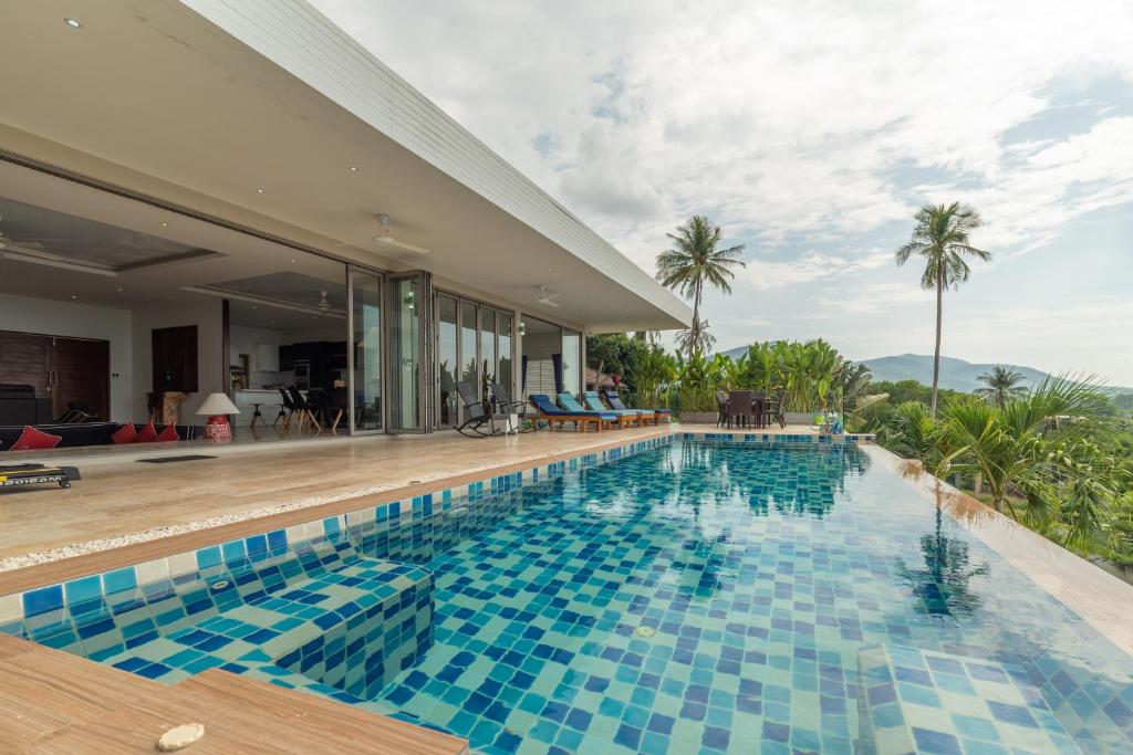 a swimming pool with a view of a villa at Villa Victoire in Mae Nam