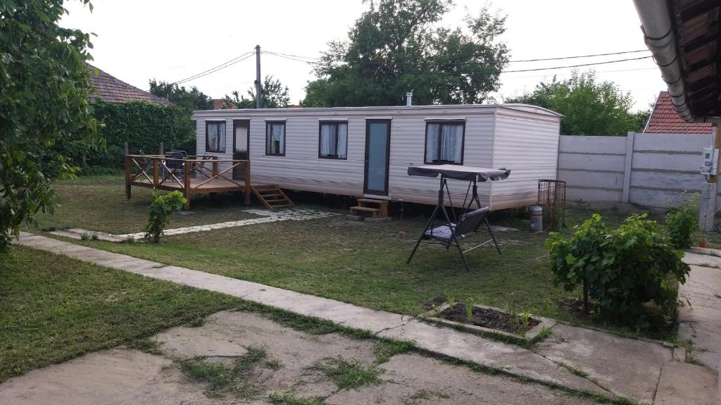 a tiny house in a yard with a grill at Kupai Apartman in Tiszaújváros