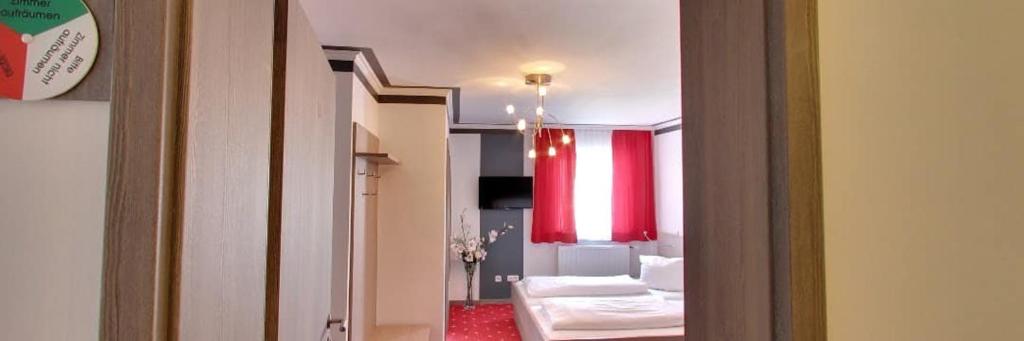mit Blick auf ein Wohnzimmer mit einem roten Vorhang in der Unterkunft Gasthof Falter in Straubing