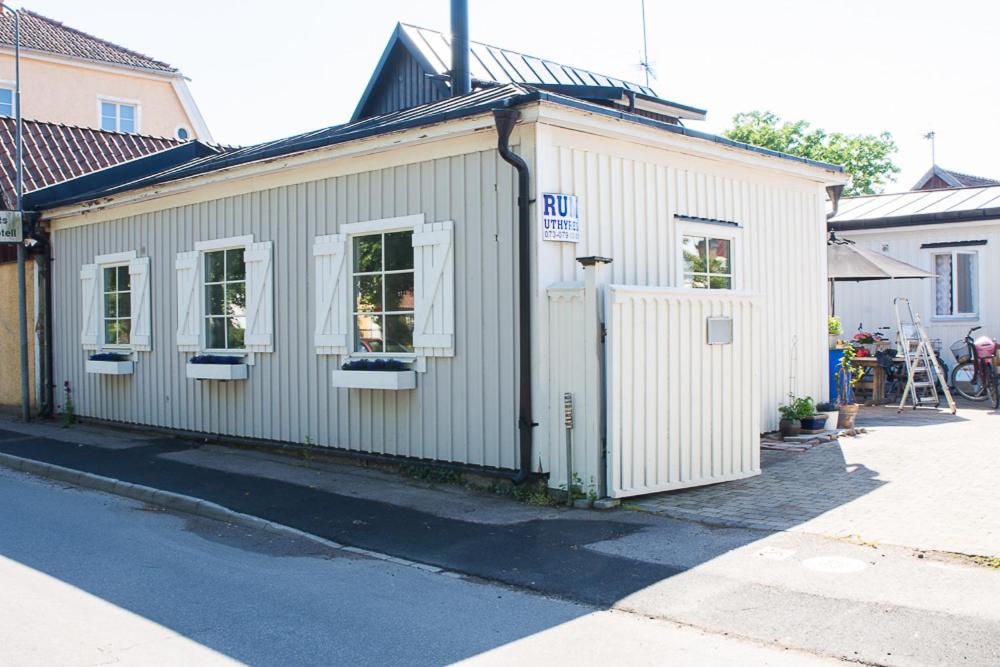 un pequeño edificio blanco con ventanas en una calle en Guest House Tullgatan 24 en Borgholm