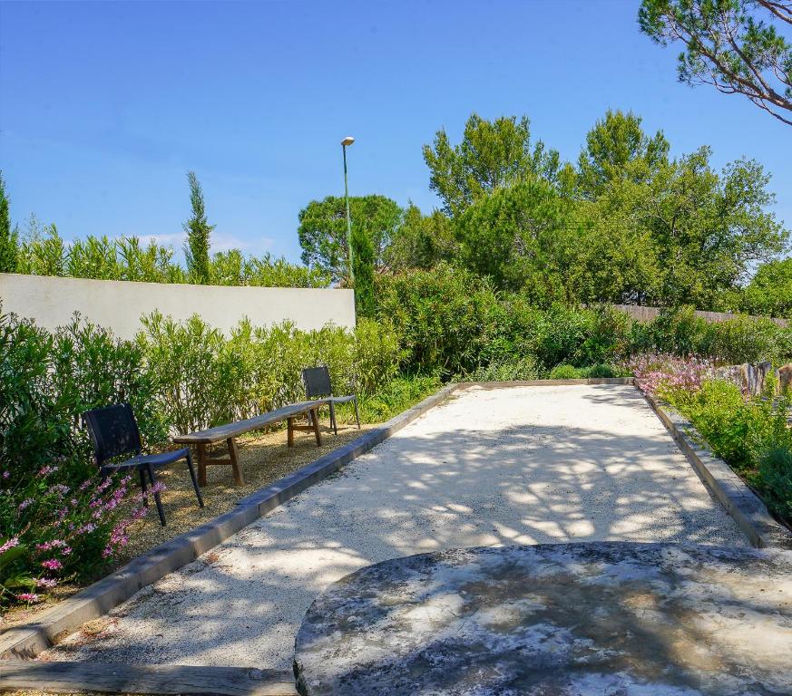 a park with two benches and trees and bushes at villa Sant-Anna in Saint-Tropez