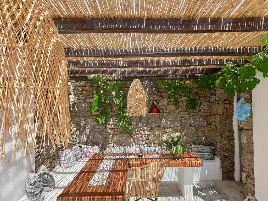 a patio with a table and a stone wall at Bellou Suites in Mýkonos City