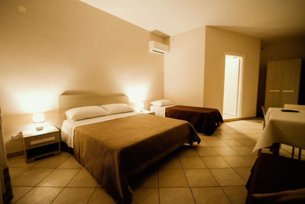 um quarto de hotel com duas camas e duas mesas em Don Fabrizio rooms em Palma di Montechiaro