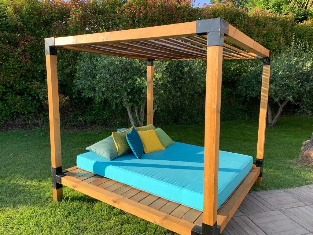 a bed with a wooden canopy in a garden at Villa Angel in La Gaude