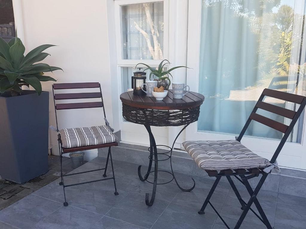 2 chaises, une table et 2 chaises dans l'établissement Aloe @ the Sea, à Mossel Bay