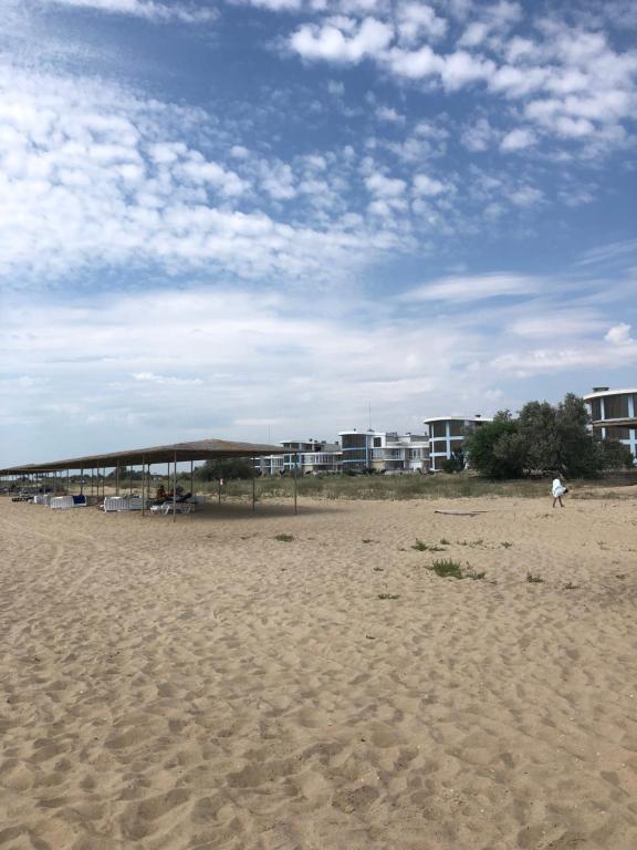 a beach with a pavilion on the sand and buildings at Apartment near the sea in Gribovka