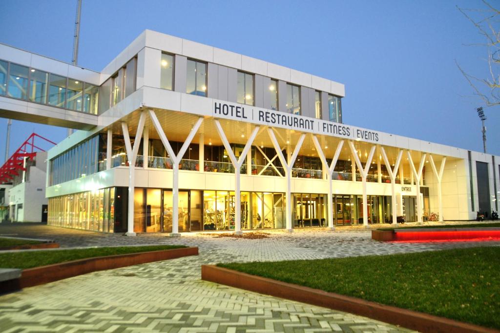 un grand bâtiment avec un panneau à l'avant dans l'établissement Fletcher Hotel-Restaurant Oss, à Oss