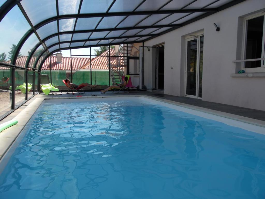 a swimming pool with a pergola over it at Chante Grelet in Châtel-Guyon