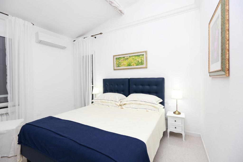 a white bedroom with a blue and white bed at Come Eravamo in Monterosso al Mare