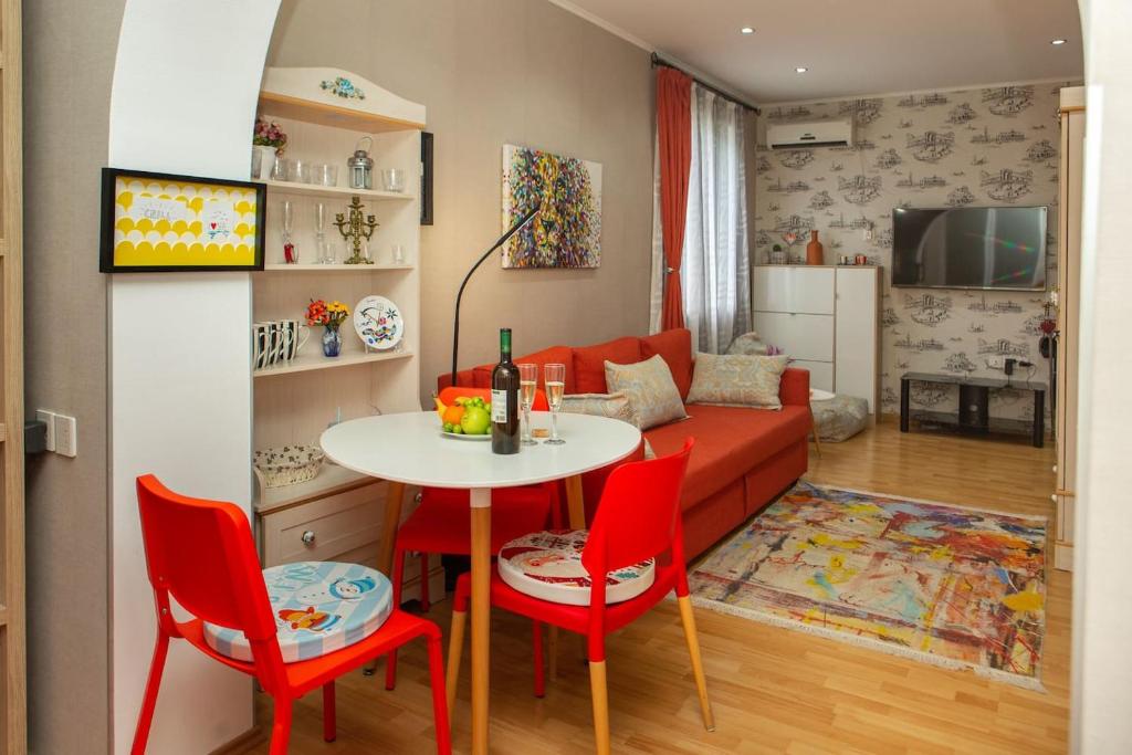 a living room with a red couch and a table and chairs at Alionas home in Tbilisi City