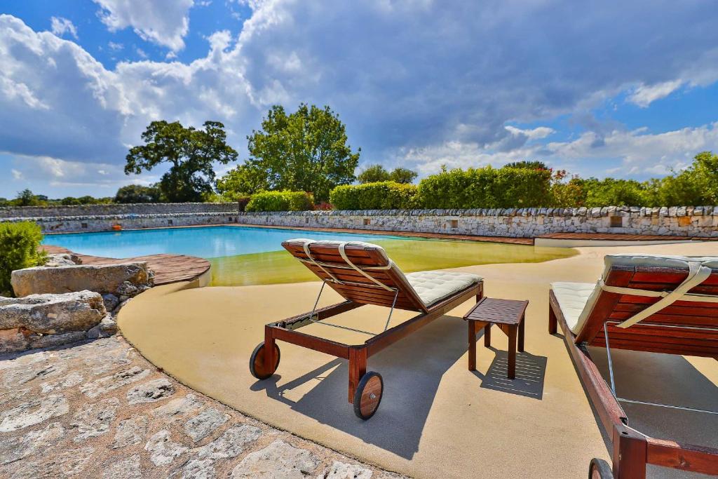 a rocking chair sitting next to a swimming pool at Masseria Casina Vitale in Ceglie Messapica