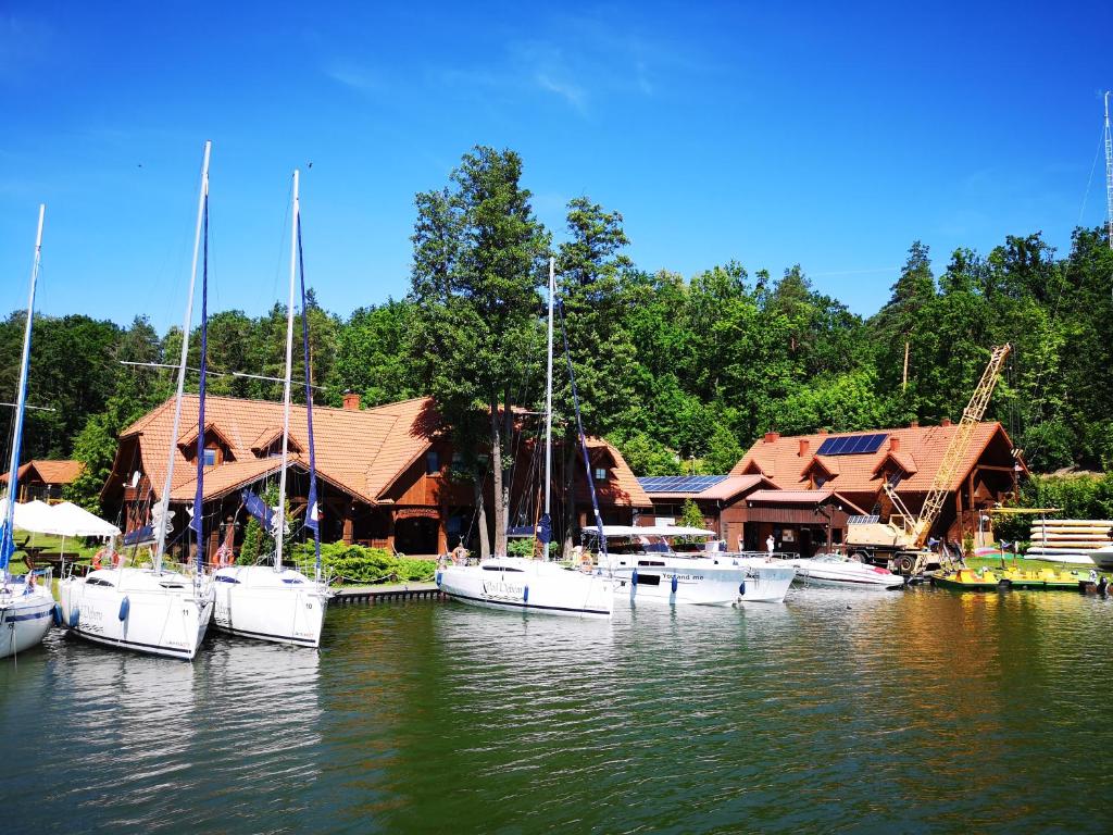 a group of boats docked in front of a building at POD DEBEM Kompleks Zeglarsko-Rekreacyjny in Ruciane-Nida